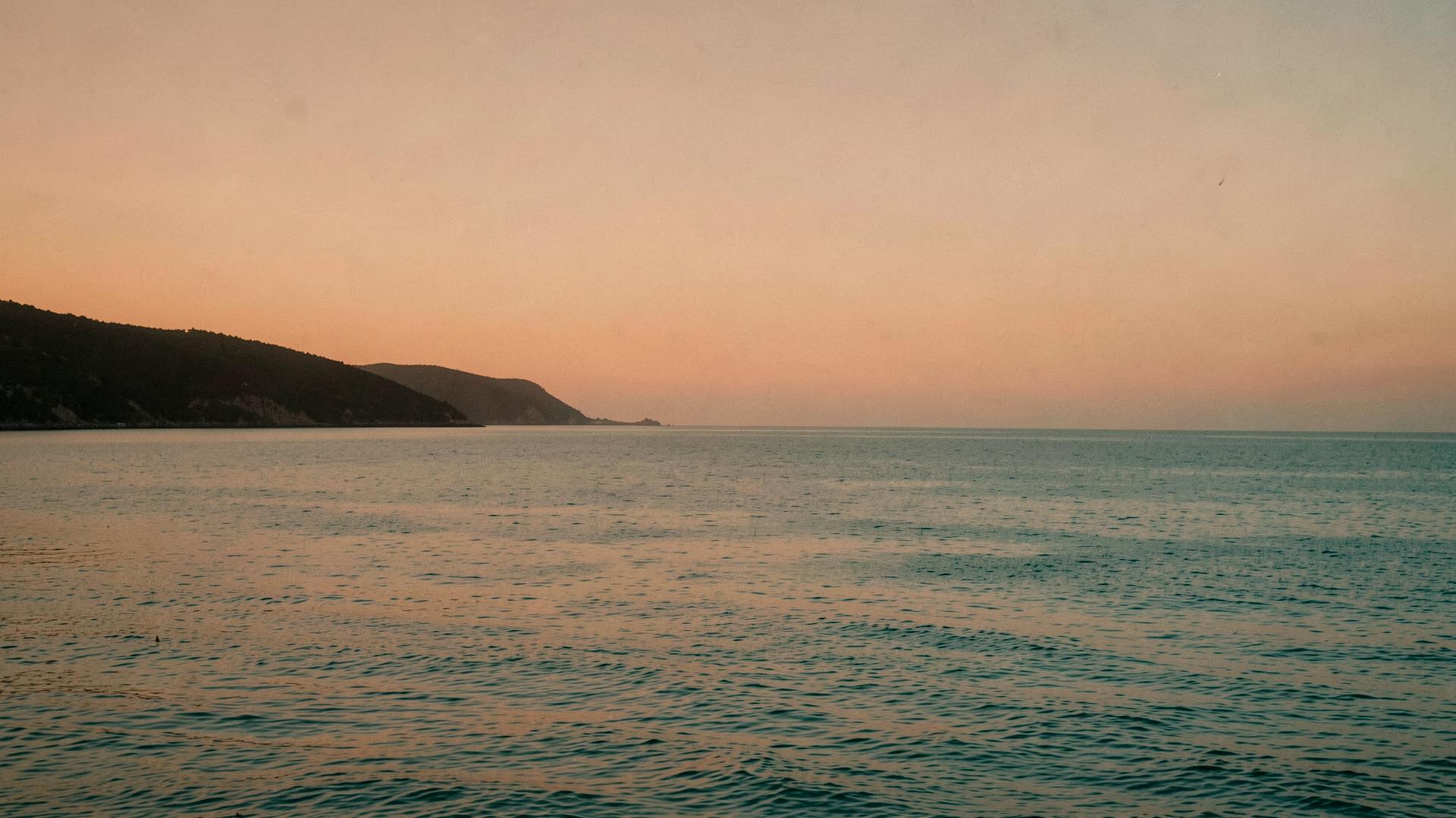 A calm bay at dusk, warm light settling over still water